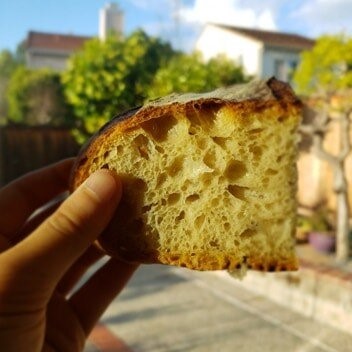 Wesley holds up a piece of artisan bread. 