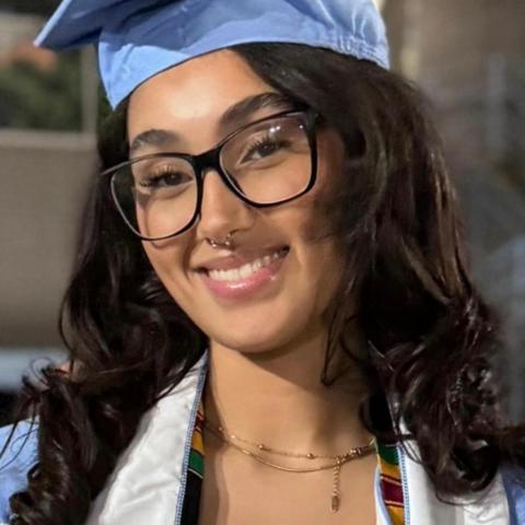 NHC member Taliyah Taylor wearing blue graduation attire and smiling.