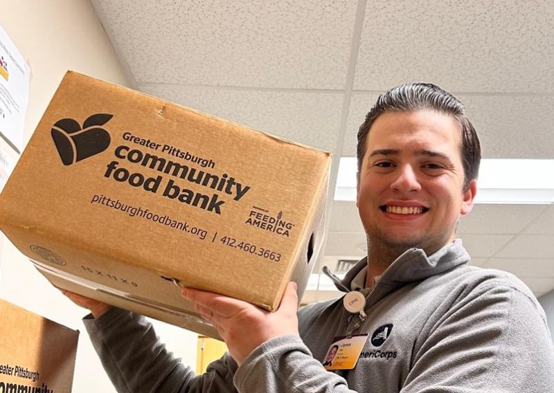 James is holding a food box.