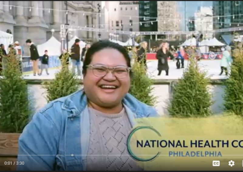 Johanna smiling in front of an ice rink. The NHC Philadelphia logo is in the bottom right corner.