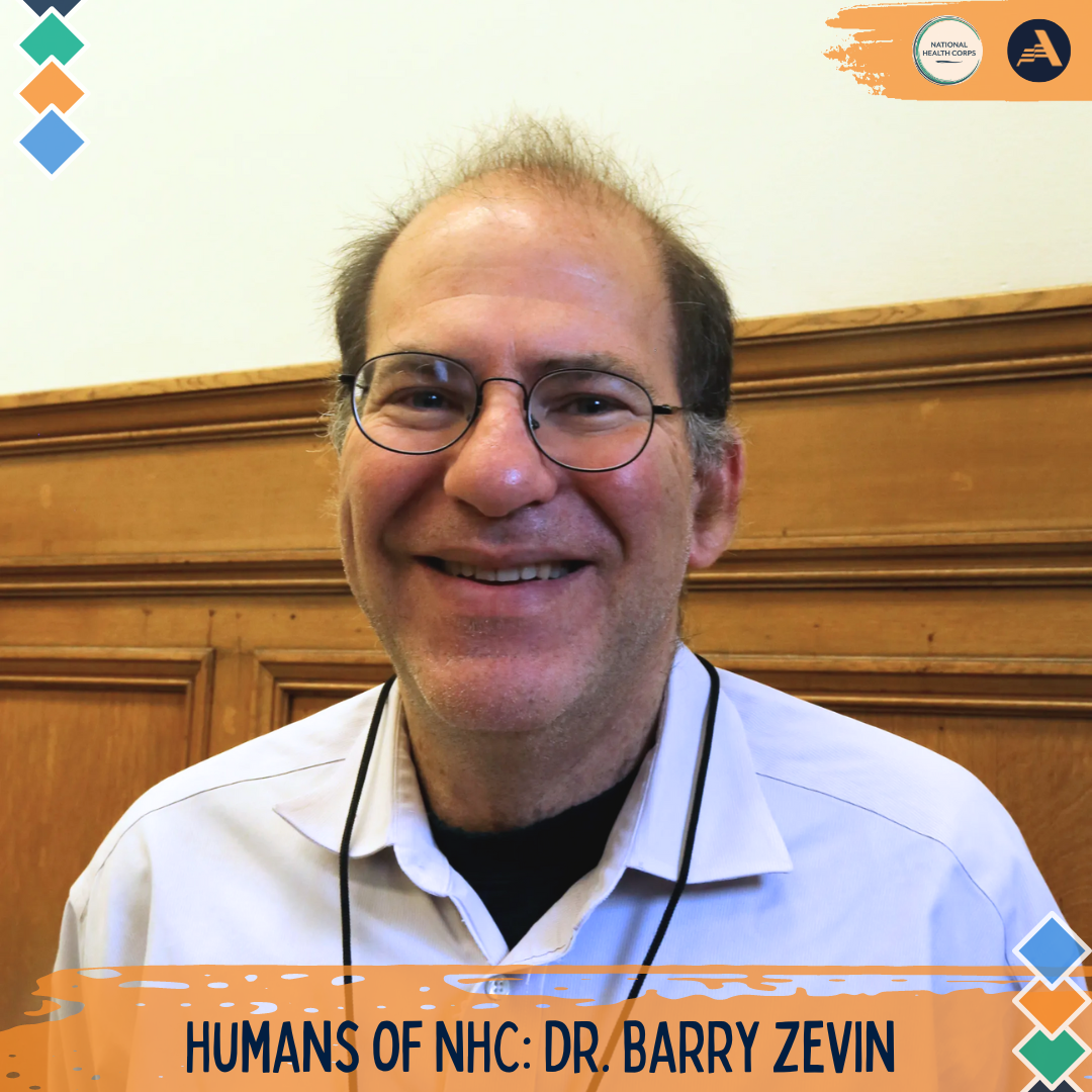 Dr. Barry Zevin is standing in the middle of the frame, facing the camera and smiling.