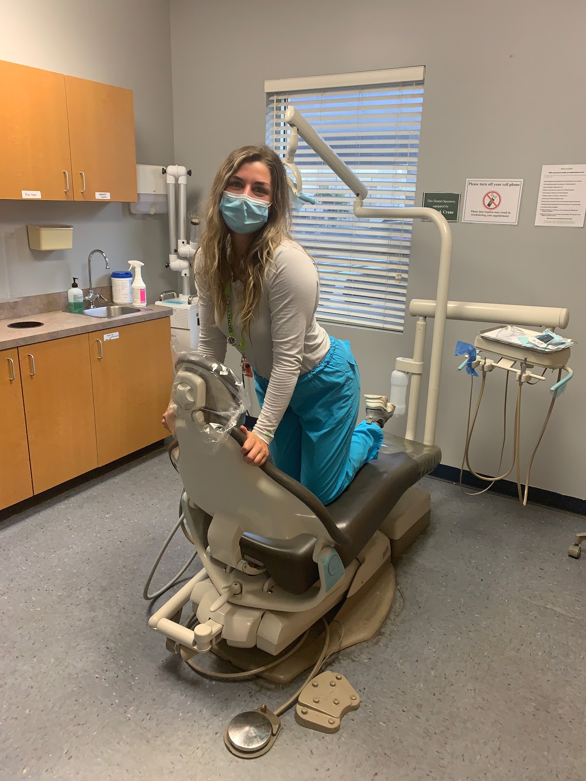 Cassidy kneeling on a dental chair